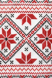 Photo of Traditional Ukrainian embroidery on white canvas as background, closeup. National handicraft