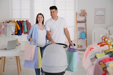 Photo of Happy pregnant woman with her husband choosing baby stroller in store. Shopping concept