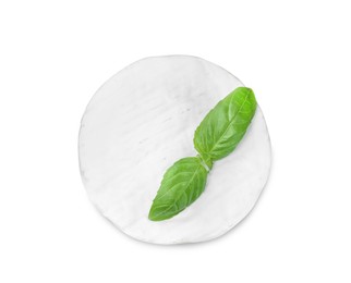 Tasty brie cheese with basil isolated on white, top view