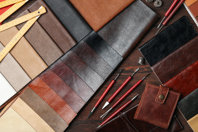 Flat lay composition with leather samples and tools on  wooden table