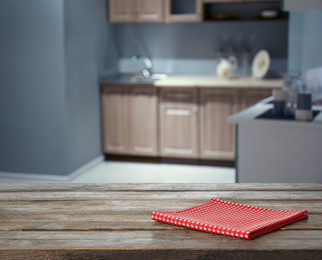 Red towel on wooden table in kitchen. Space for text