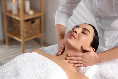 Photo of Beautiful woman receiving massage in beauty salon, closeup