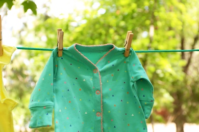 Laundry line with child's clothes outdoors on sunny day