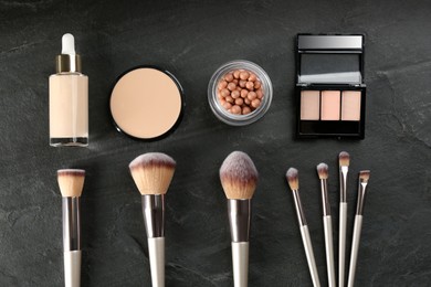 Flat lay composition with makeup brushes on black stone table