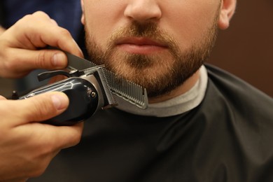 Professional hairdresser working with client in barbershop, closeup 