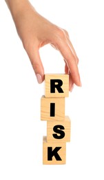 Woman stacking wooden cubes with word Risk on white background, closeup