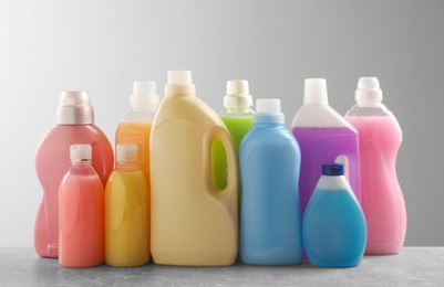 Different bottles with detergents on grey table