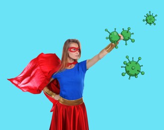 Young woman wearing superhero costume fighting against viruses on turquoise background