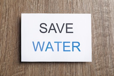 Photo of Card with words Save Water on wooden table, top view