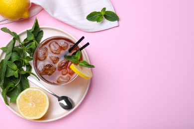 Delicious iced tea with lemon and mint on pink background, flat lay. Space for text