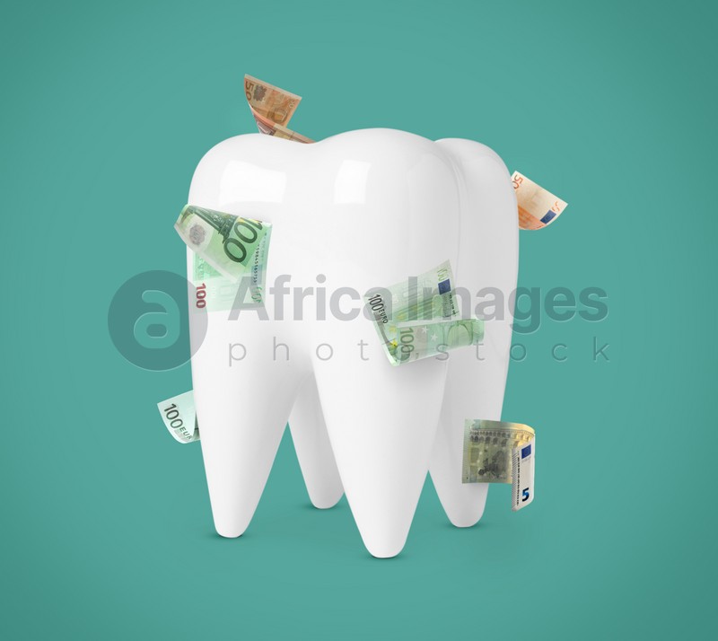 Model of tooth with dollar banknotes on teal background. Concept of expensive dental procedures