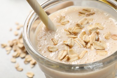 Glass of tasty smoothie with oatmeal on table, closeup