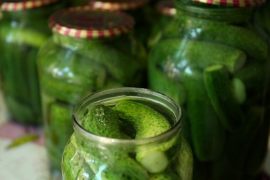 Many pickling jars with fresh cucumbers, closeup