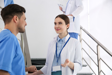 Female doctor talking to colleague on staircase in clinic