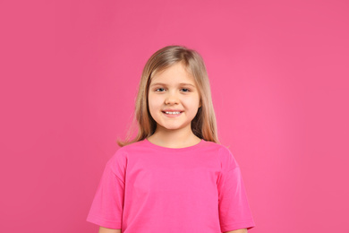 Cute little girl wearing casual outfit on pink background