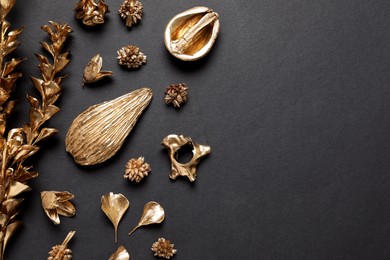 Photo of Flat lay composition with golden dried flowers on black background. Space for text