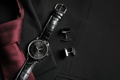 Flat lay composition with luxury wrist watch on black jacket