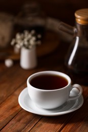 Cup with delicious tea on wooden table