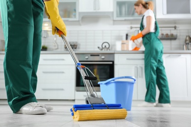 Cleaning service team at work in kitchen, closeup