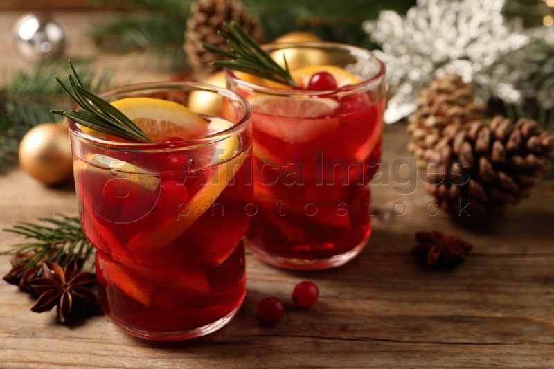 Delicious punch drink with cranberries and orange on wooden table