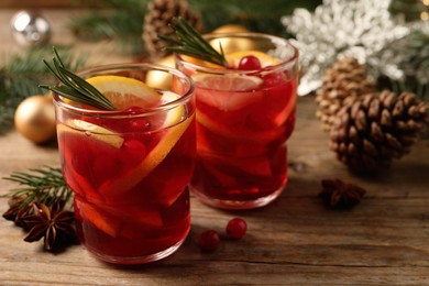 Delicious punch drink with cranberries and orange on wooden table