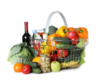 Shopping basket and grocery products on white background