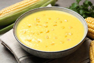 Delicious creamy corn soup on grey table, closeup
