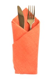 Photo of Golden fork and knife wrapped in orange napkin on white background, top view