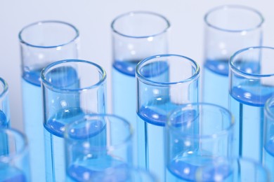 Test tubes with reagents on light blue background, closeup. Laboratory analysis