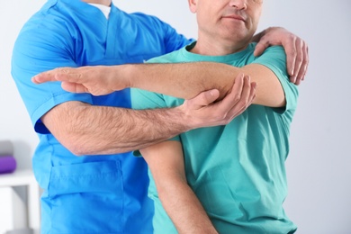 Doctor working with patient in hospital, closeup. Rehabilitation physiotherapy