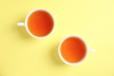 Cups of delicious tea on color background, top view
