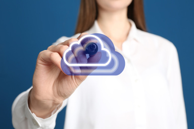 Woman pointing at virtual clouds icon on blue background, closeup of hand. Data storage concept