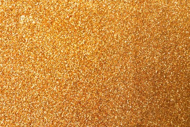 Beautiful shiny golden glitter as background, closeup