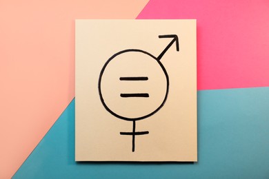 Photo of Card with equal sign and gender symbols on color background, top view