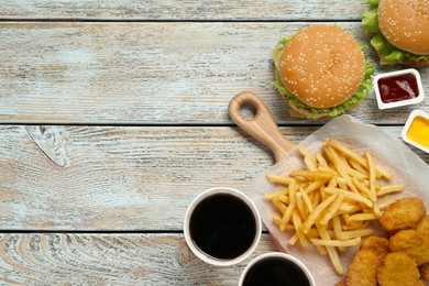 Photo of Flat lay composition with delicious fast food menu on white wooden table. Space for text