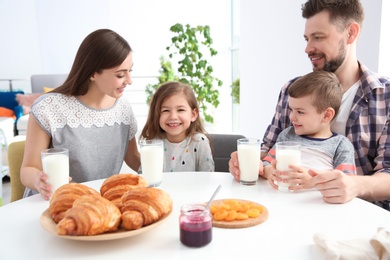 Happy family having breakfast with milk at table