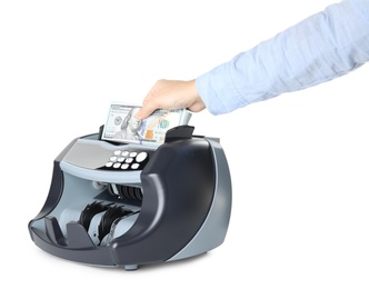 Woman putting money into counting machine on white background, closeup