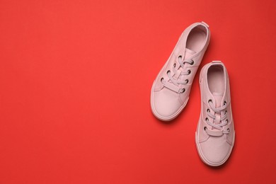 Pair of comfortable sports shoes on red background, flat lay. Space for text