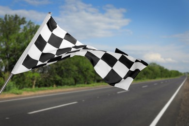 Checkered racing finish flag and asphalt road outdoors