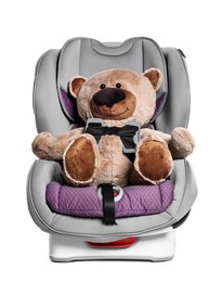 Photo of Teddy bear in child safety car seat on white background