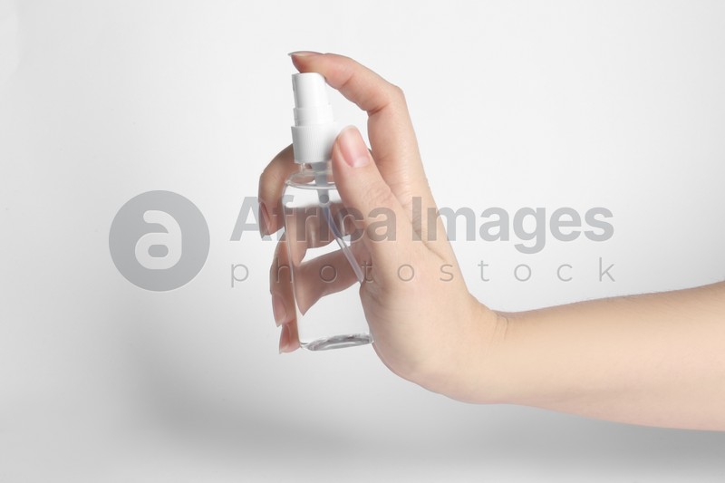 Woman holding antiseptic spray on white background, closeup