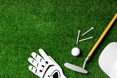 Flat lay composition with golf equipment on green course. Space for text