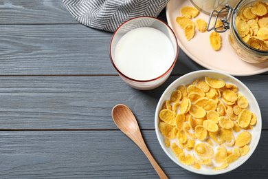 Flat lay composition with tasty corn flakes on grey wooden table. Space for text