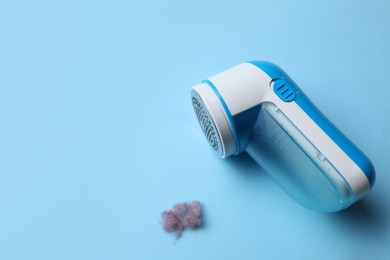 Modern fabric shaver and lint on light blue background. Space for text