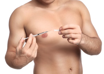 Athletic man with syringe on white background, closeup. Doping concept
