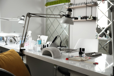 Photo of Professional equipment for manicure on table in beauty salon