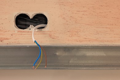 Photo of Socket holes and cables on wall, closeup. Space for text