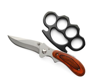 Black brass knuckles and knife on white background, top view