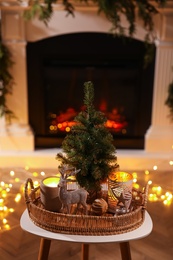 Composition with decorative reindeer and Christmas tree near fireplace in room