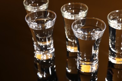 Shot glasses with vodka on dark table